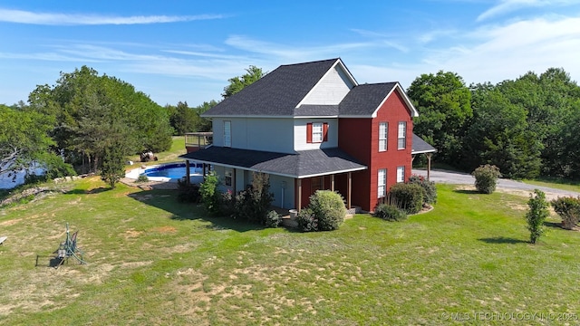 76 Cris, Durant, OK 74701 - view of side of property with roof with shingles, a yard, an outdoor pool, and driveway