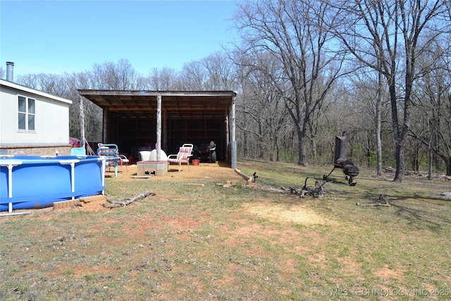 17414 Bridgeview Rd, Madill, OK 73446 - view of yard with a carport, an outbuilding, and an outdoor pool