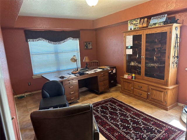 office area featuring baseboards, a textured ceiling, and a textured wall