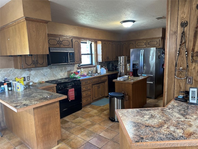 kitchen featuring backsplash, a sink, visible vents, a peninsula, and black appliances