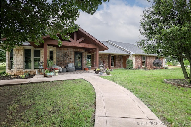 back of property featuring a lawn, brick siding, and roof with shingles