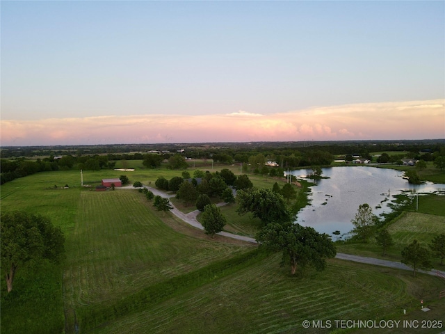 aerial view at dusk with a water view and a rural view