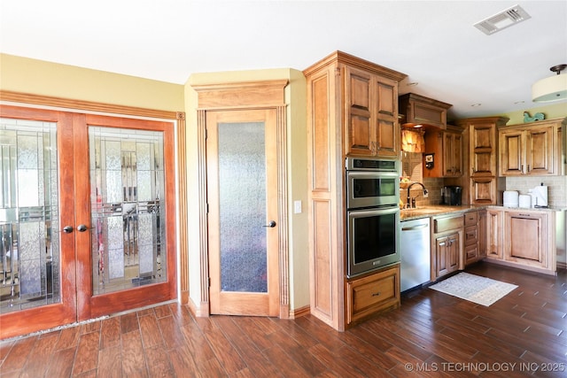 kitchen with visible vents, stainless steel appliances, dark wood-type flooring, a sink, and french doors