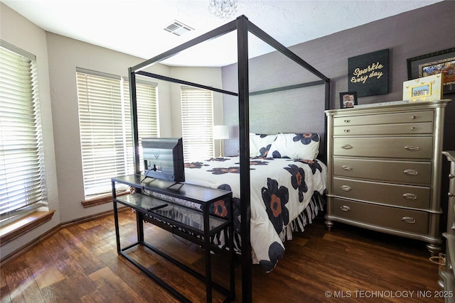 bedroom featuring dark wood finished floors and visible vents