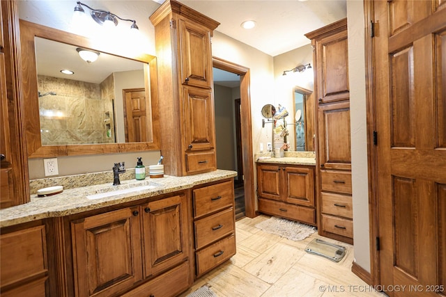 bathroom with a tile shower, recessed lighting, and vanity