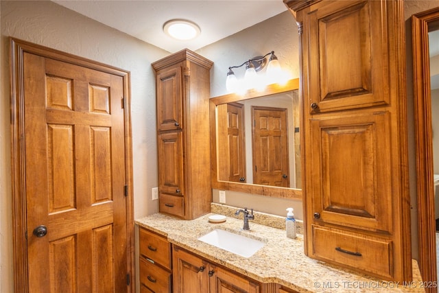 bathroom with a textured wall and vanity