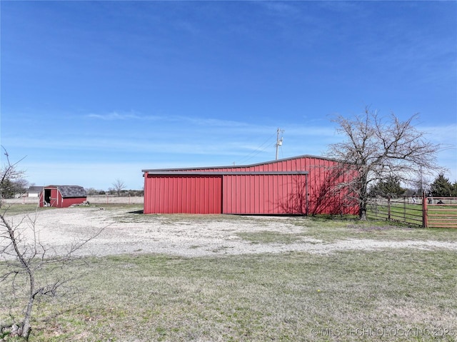view of pole building featuring fence and a lawn