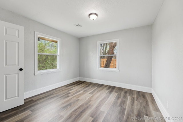 719 S 7th St, Muskogee, OK 74401 - spare room with healthy amount of natural light and wood finished floors