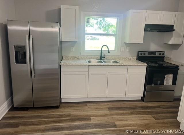 719 S 7th St, Muskogee, OK 74401 - kitchen featuring stainless steel appliances, under cabinet range hood, white cabinets, and dark wood finished floors