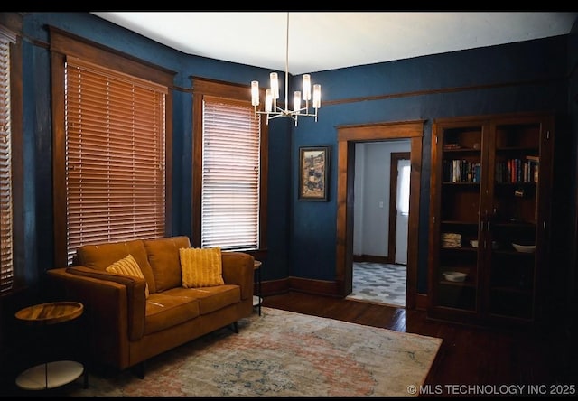 sitting room featuring a chandelier, wood finished floors, and baseboards