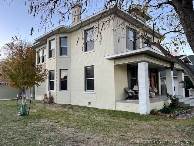 121 F SW, Ardmore, OK 73401 - view of property exterior with brick siding, a chimney, a lawn, and a porch
