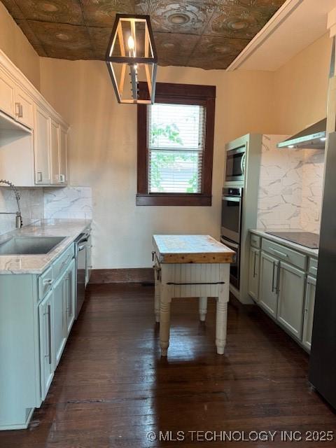 121 F SW, Ardmore, OK 73401 - kitchen featuring an ornate ceiling, stainless steel appliances, a sink, dark wood finished floors, and backsplash