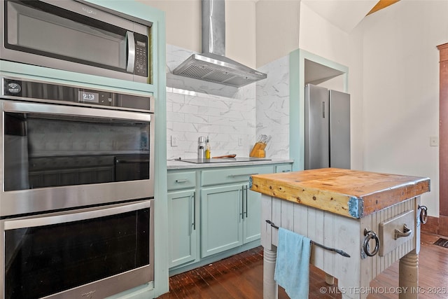 121 F SW, Ardmore, OK 73401 - kitchen with appliances with stainless steel finishes, wall chimney exhaust hood, butcher block counters, and dark wood finished floors