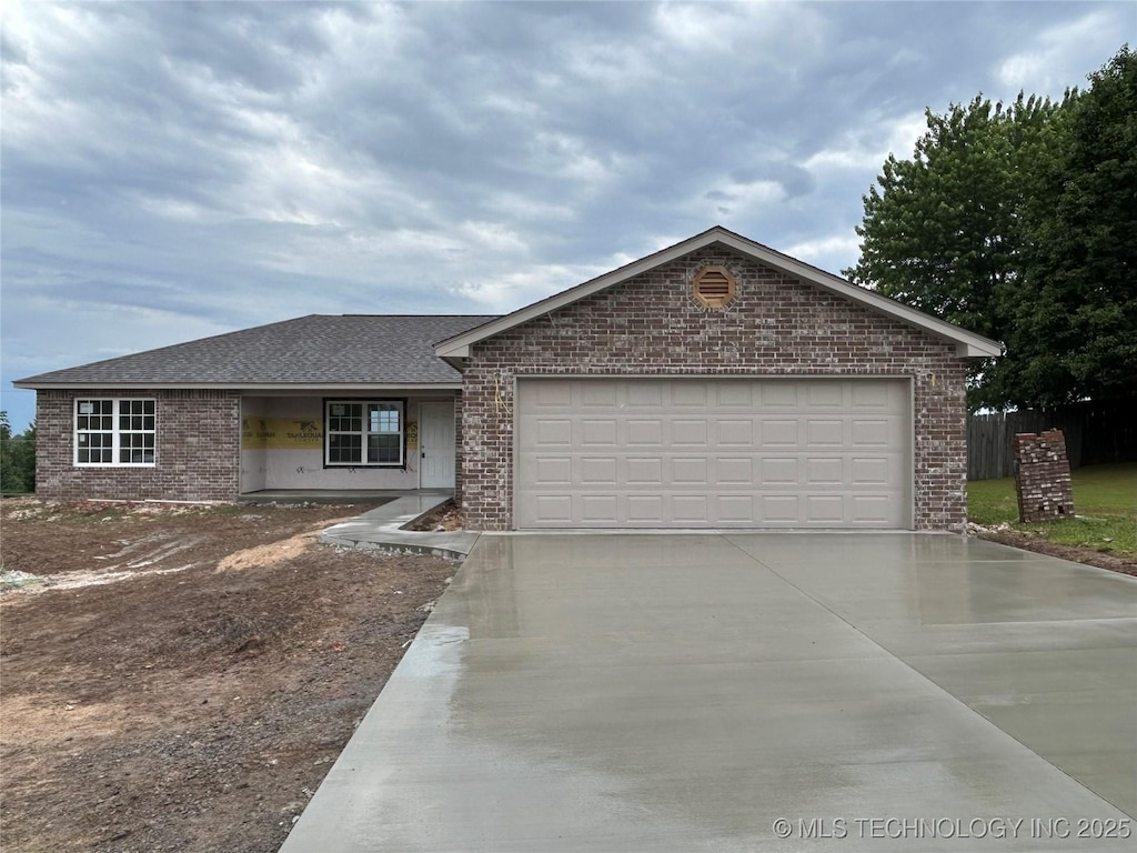 14879 N Trent St, Tahlequah, OK 74464 - ranch-style home with brick siding, concrete driveway, an attached garage, and a shingled roof