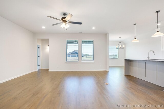 23192 E 106th St S, Broken Arrow, OK 74014 - unfurnished living room with a sink, wood finished floors, ceiling fan with notable chandelier, baseboards, and recessed lighting