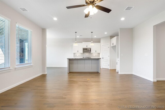 23192 E 106th St S, Broken Arrow, OK 74014 - unfurnished living room featuring a ceiling fan, recessed lighting, dark wood finished floors, and visible vents