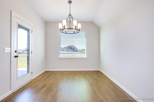 23192 E 106th St S, Broken Arrow, OK 74014 - unfurnished dining area featuring a notable chandelier, baseboards, vaulted ceiling, and wood finished floors