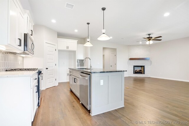 23192 E 106th St S, Broken Arrow, OK 74014 - kitchen with ceiling fan, stainless steel appliances, a sink, light wood-type flooring, and backsplash