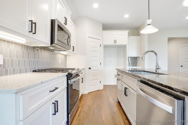 23192 E 106th St S, Broken Arrow, OK 74014 - kitchen with light stone counters, a sink, stainless steel appliances, white cabinets, and light wood-style floors