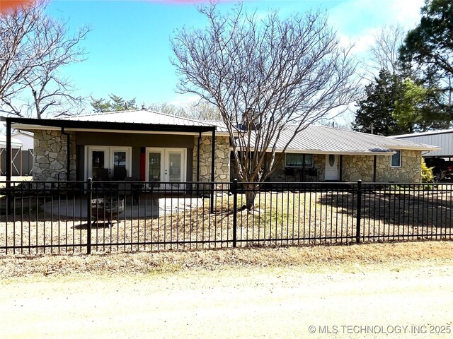 2828 Riverview Rd, Kingston, OK 73439 - view of front of property featuring stone siding, metal roof, and fence private yard