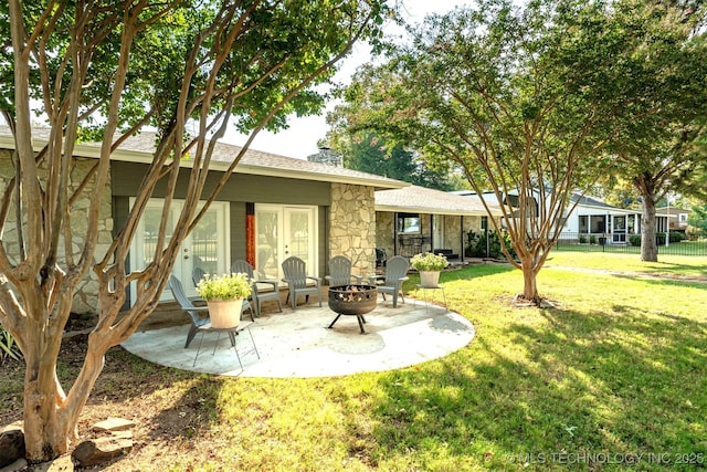 2828 Riverview Rd, Kingston, OK 73439 - rear view of house featuring fence, a yard, a patio, stone siding, and a fire pit
