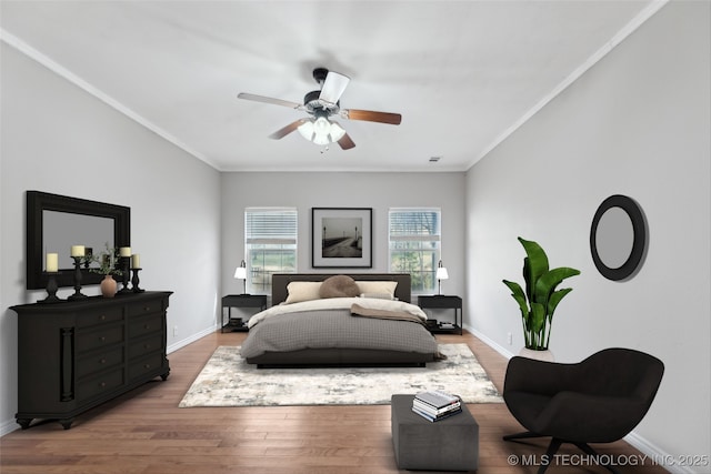bedroom featuring crown molding, baseboards, and wood finished floors