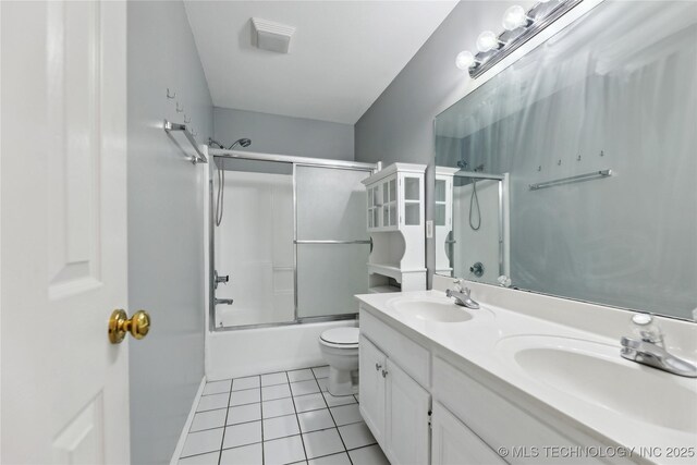 full bath featuring a sink, tile patterned floors, toilet, and double vanity