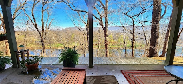 view of patio / terrace with a water view and a view of trees