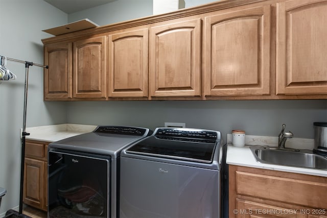 washroom featuring cabinet space, independent washer and dryer, and a sink