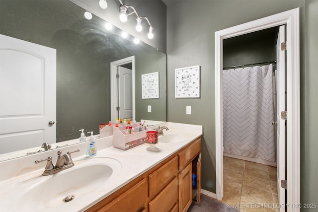 full bath featuring double vanity, a sink, and tile patterned floors