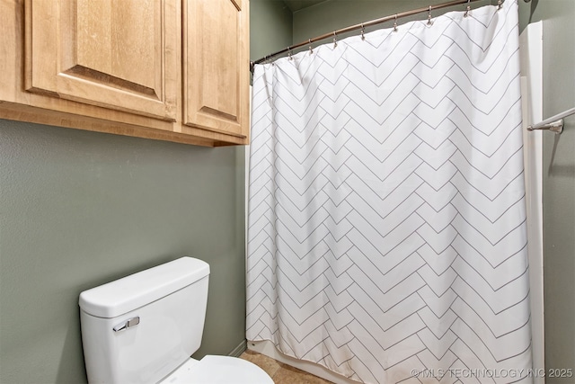 bathroom with toilet and curtained shower