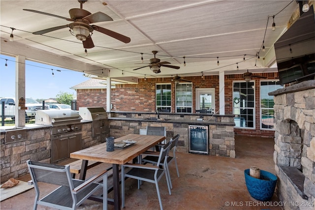 view of patio with beverage cooler, outdoor dining area, exterior kitchen, and ceiling fan