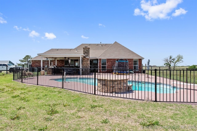 view of swimming pool featuring fence, a fenced in pool, a lawn, a ceiling fan, and a patio