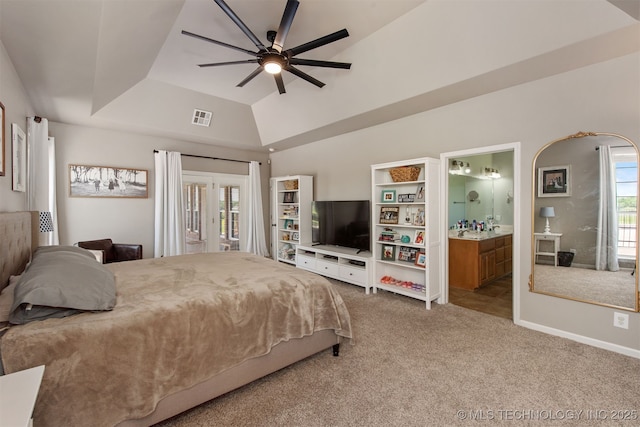 bedroom featuring visible vents, baseboards, ensuite bathroom, carpet, and a tray ceiling