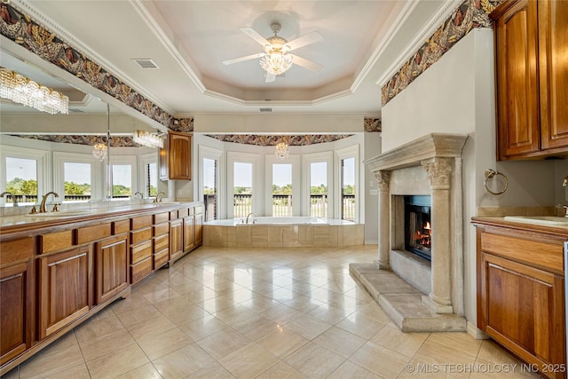 8315 N 99th E Ave, Owasso, OK 74055 - bathroom with double vanity, a bath, a tray ceiling, plenty of natural light, and ornamental molding