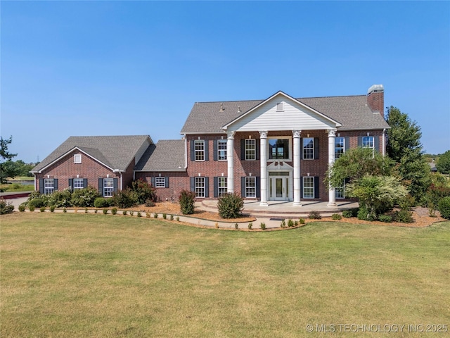 8315 N 99th E Ave, Owasso, OK 74055 - greek revival house featuring brick siding, a front yard, and a chimney