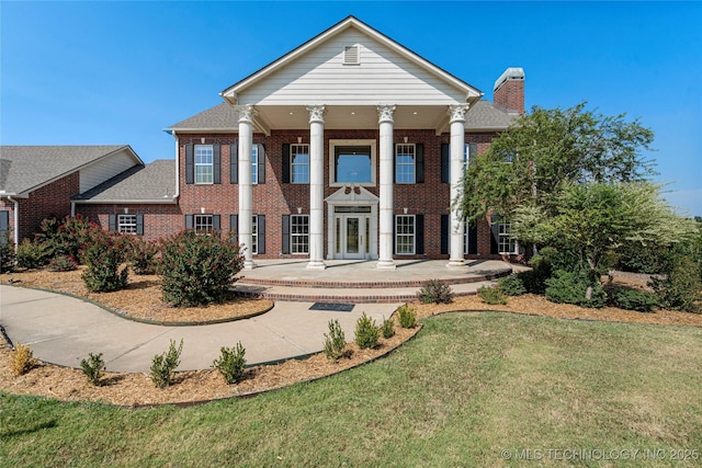 8315 N 99th E Ave, Owasso, OK 74055 - view of front of property with brick siding, a chimney, a front yard, and roof with shingles