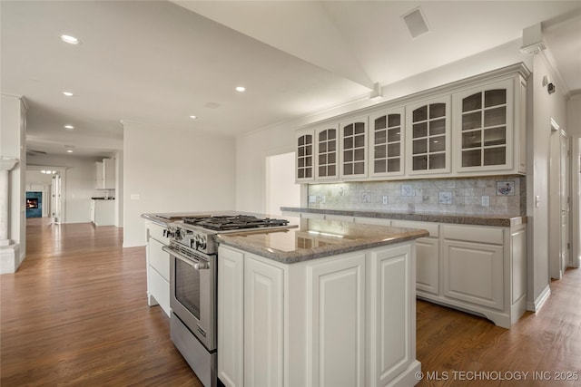 8315 N 99th E Ave, Owasso, OK 74055 - kitchen with high end range, a kitchen island, backsplash, glass insert cabinets, and wood finished floors