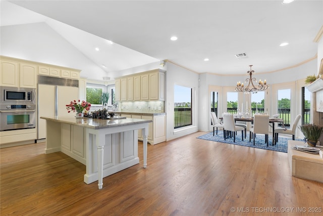 8315 N 99th E Ave, Owasso, OK 74055 - kitchen with built in appliances, cream cabinets, a chandelier, recessed lighting, and decorative backsplash