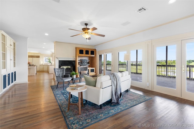 8315 N 99th E Ave, Owasso, OK 74055 - living room with a multi sided fireplace, ceiling fan, recessed lighting, wood finished floors, and crown molding