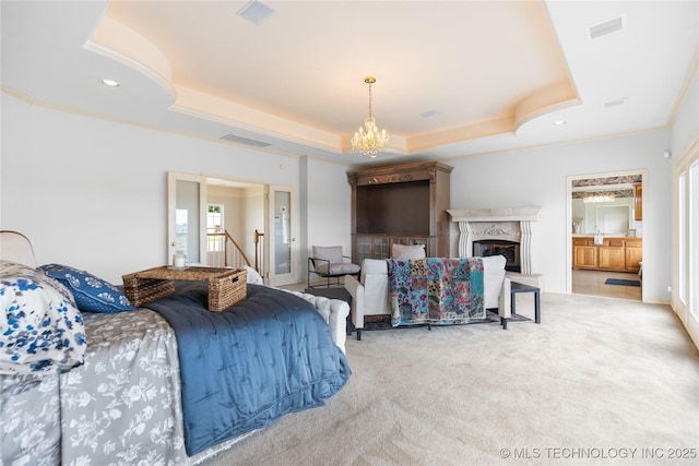 8315 N 99th E Ave, Owasso, OK 74055 - bedroom featuring a tray ceiling, carpet flooring, a chandelier, ensuite bath, and a high end fireplace