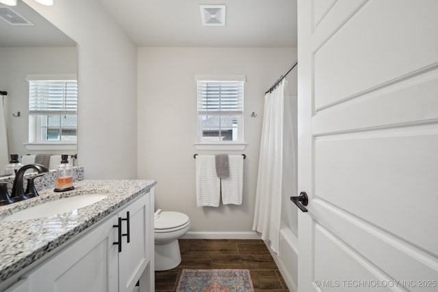 bathroom with visible vents, wood finished floors, and plenty of natural light