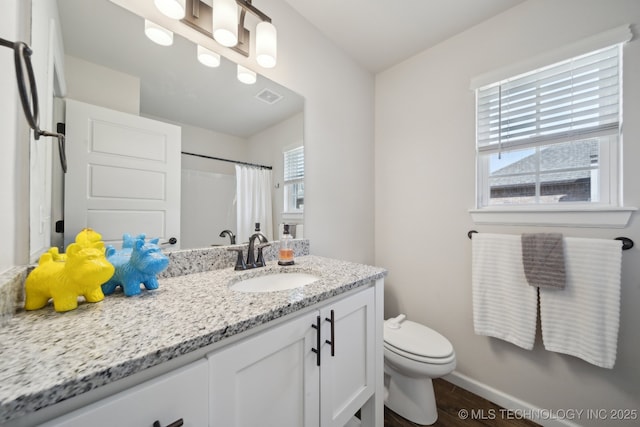 full bath featuring a shower with curtain, toilet, vanity, baseboards, and visible vents