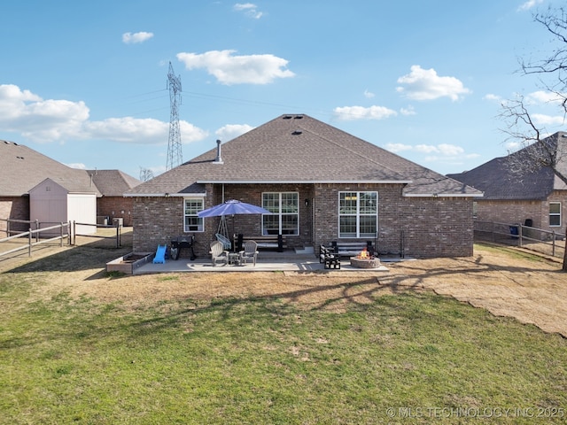 rear view of property with a patio, a lawn, a fenced backyard, and brick siding