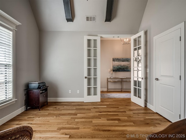interior space with light wood finished floors, vaulted ceiling, and french doors