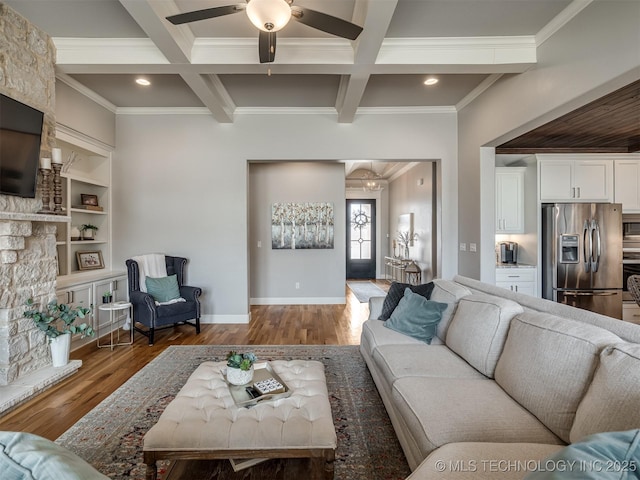 living area featuring a ceiling fan, ornamental molding, beam ceiling, and wood finished floors