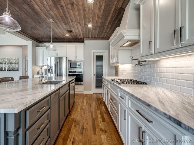 5519 E 123rd St S, Bixby, OK 74008 - kitchen featuring stainless steel appliances, wall chimney exhaust hood, wood ceiling, a sink, and white cabinetry