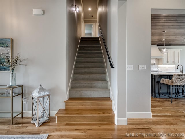staircase featuring baseboards and wood finished floors
