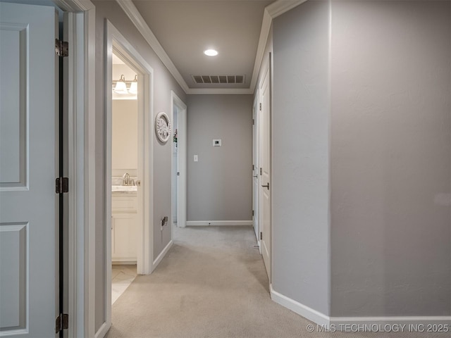 hall with recessed lighting, baseboards, a sink, visible vents, and light carpet