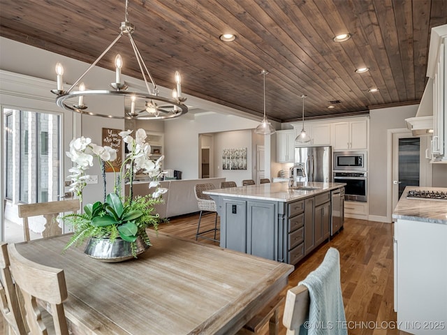 dining area with a notable chandelier, recessed lighting, wood finished floors, and wooden ceiling